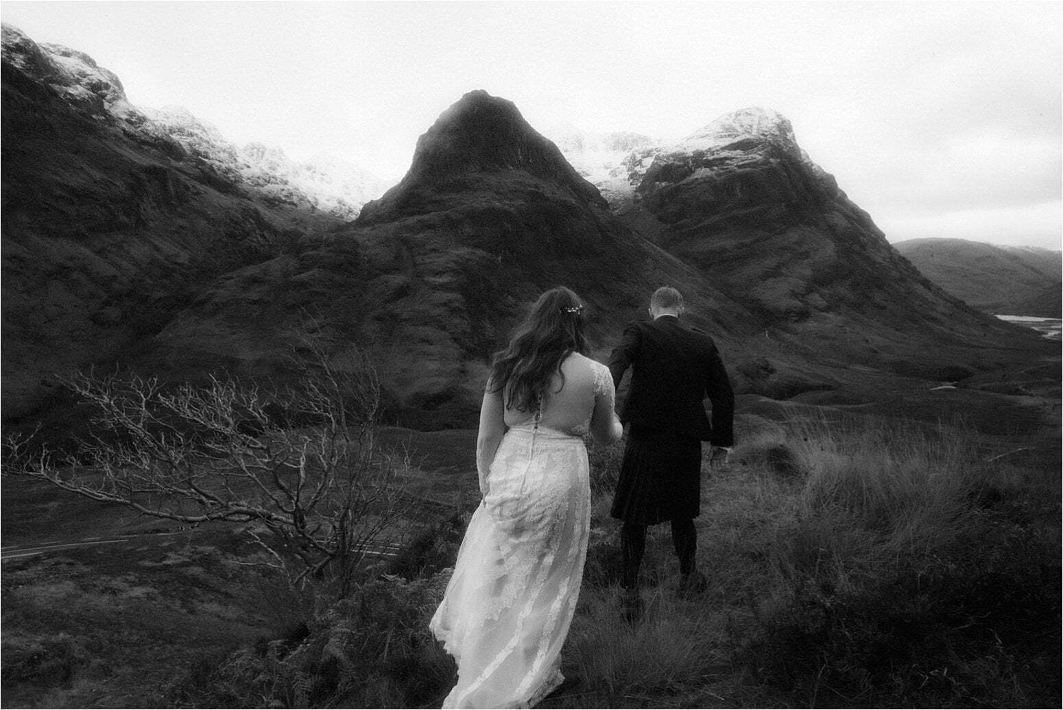 bride and groom standing in the mountains of scotland