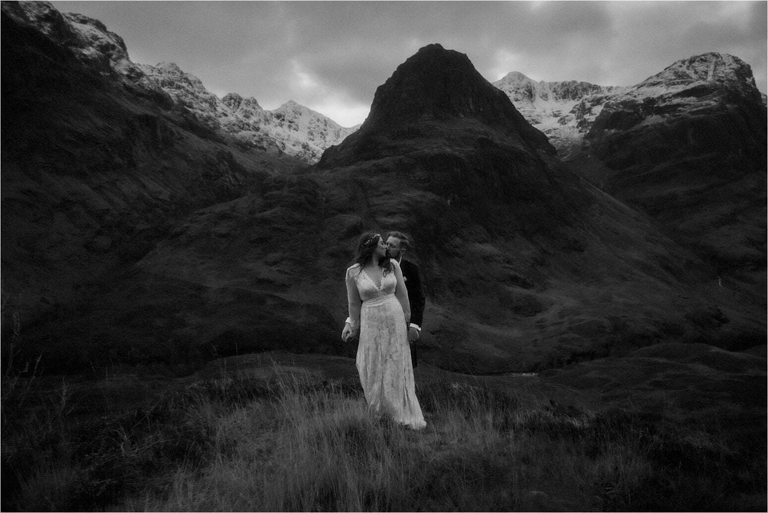 bride and groom standing in the mountains of scotland