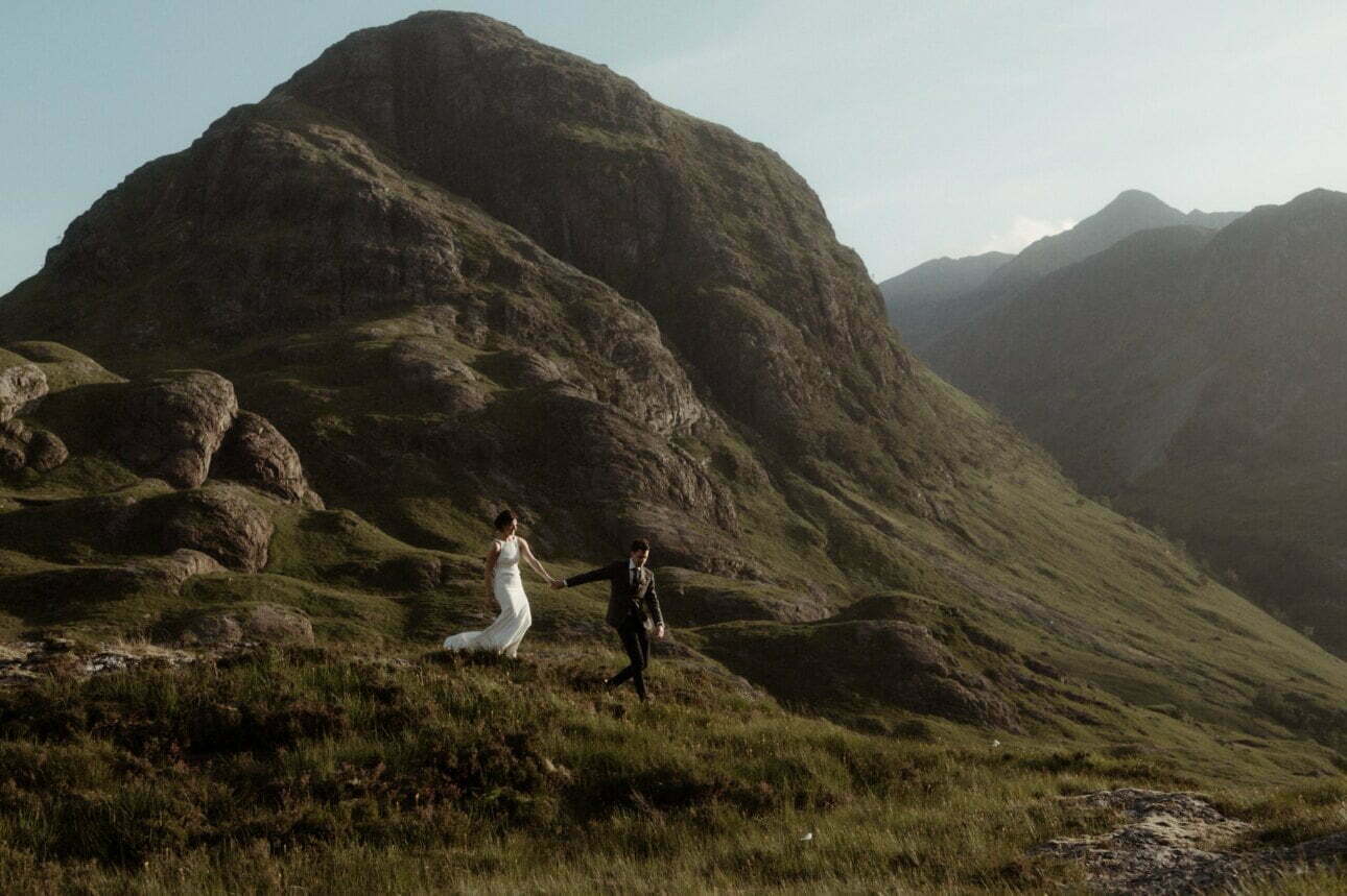 elope to Scotland couple in Glencoe walking in the mountains in the sunshine