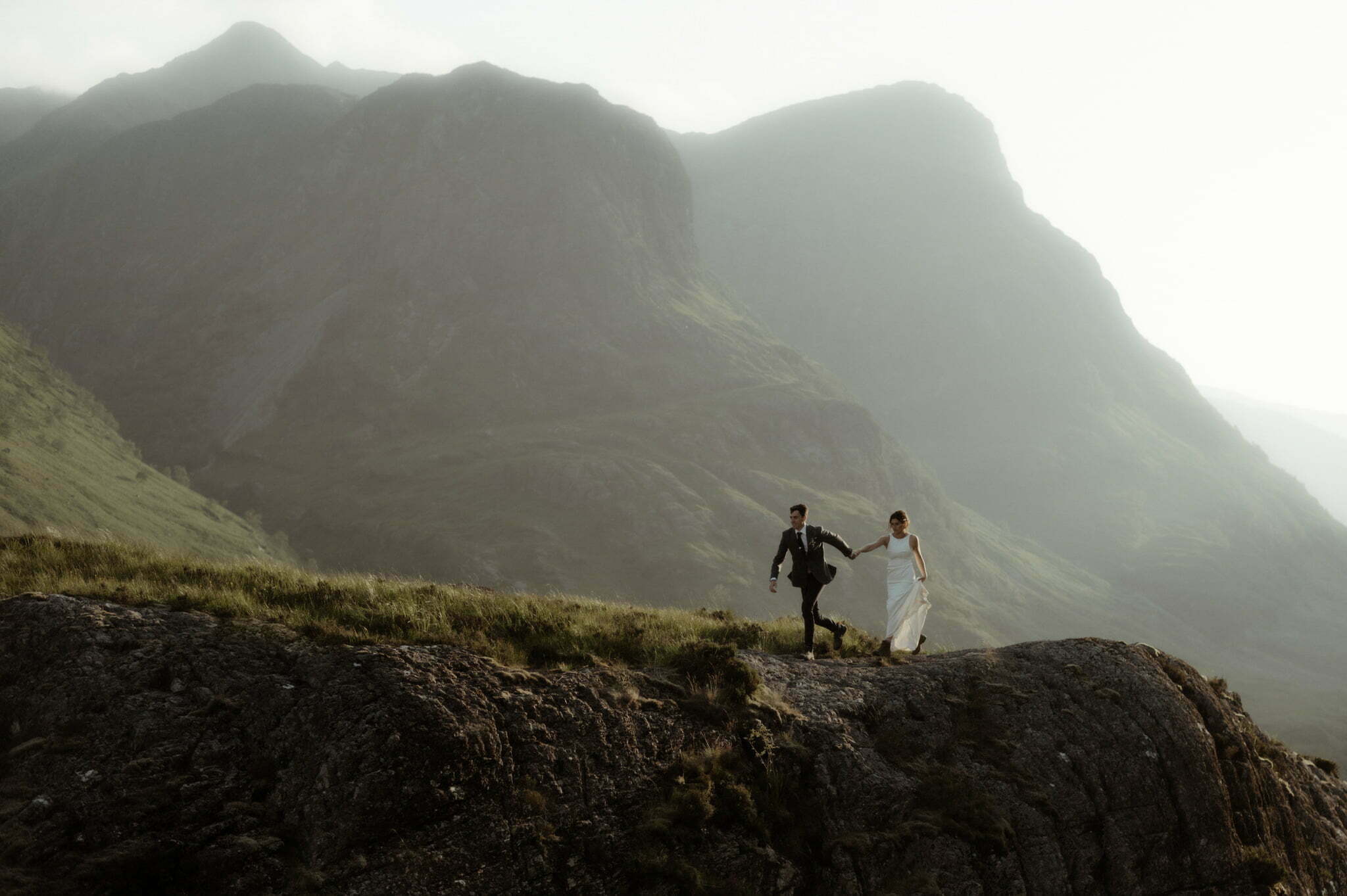 Glencoe elopement couple running in the mountains