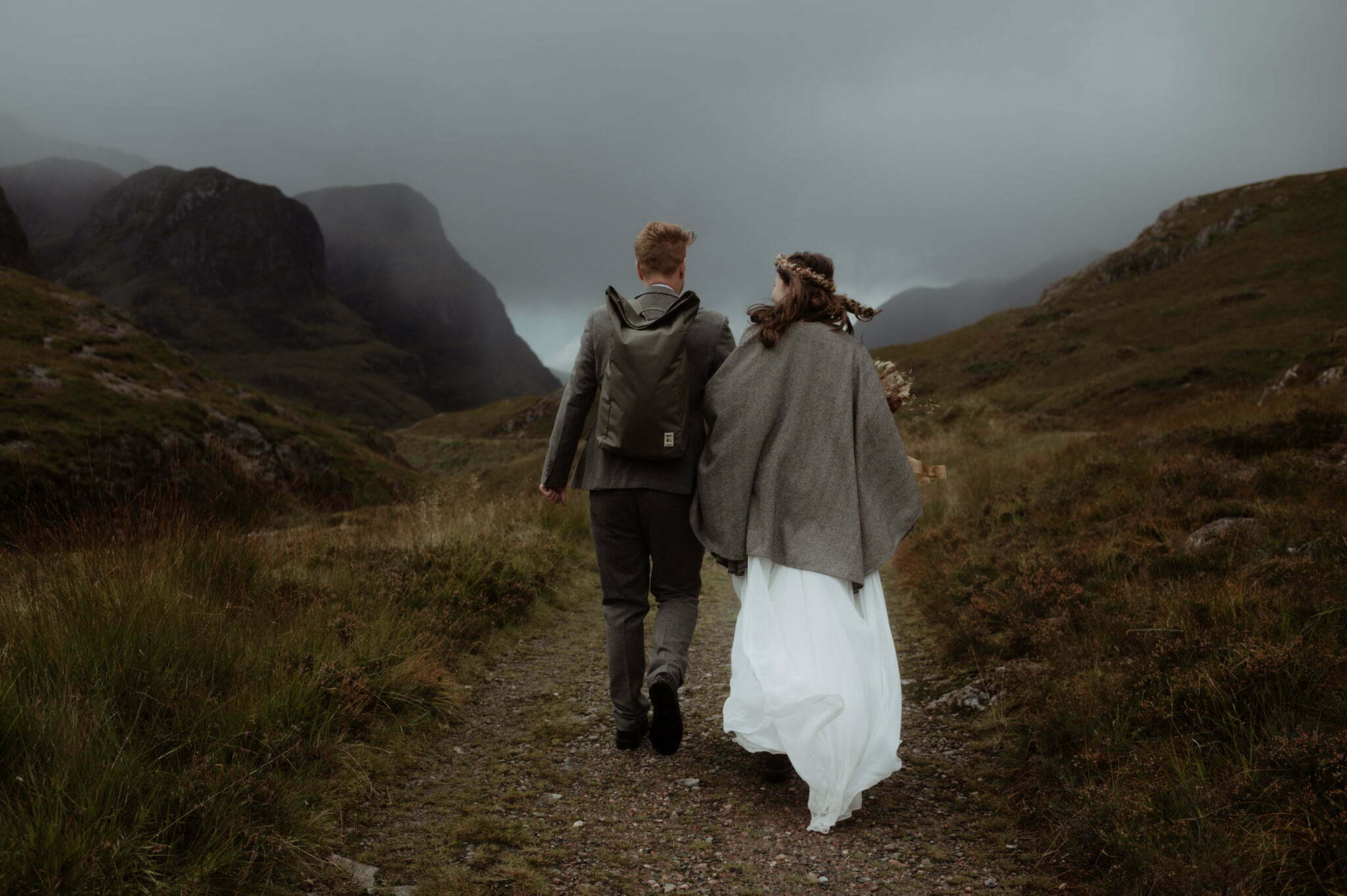 Glencoe elopement couple walking in the mountains with backpacks