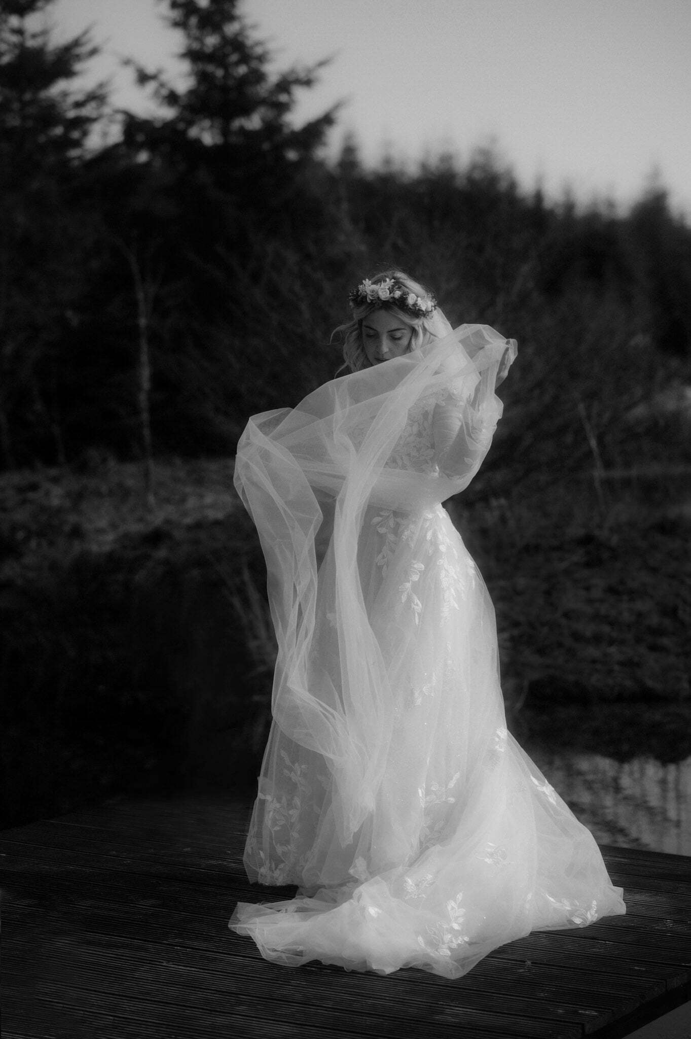 elope to scotland bride standing in sunlight with wedding dress blowing in the wind