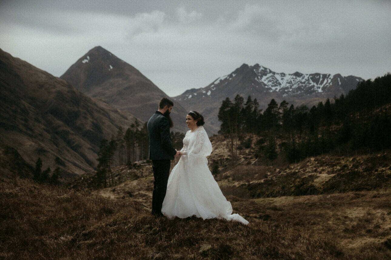 eilean donan wedding in the scottish highlands couple walking in the mountains of glen shiel