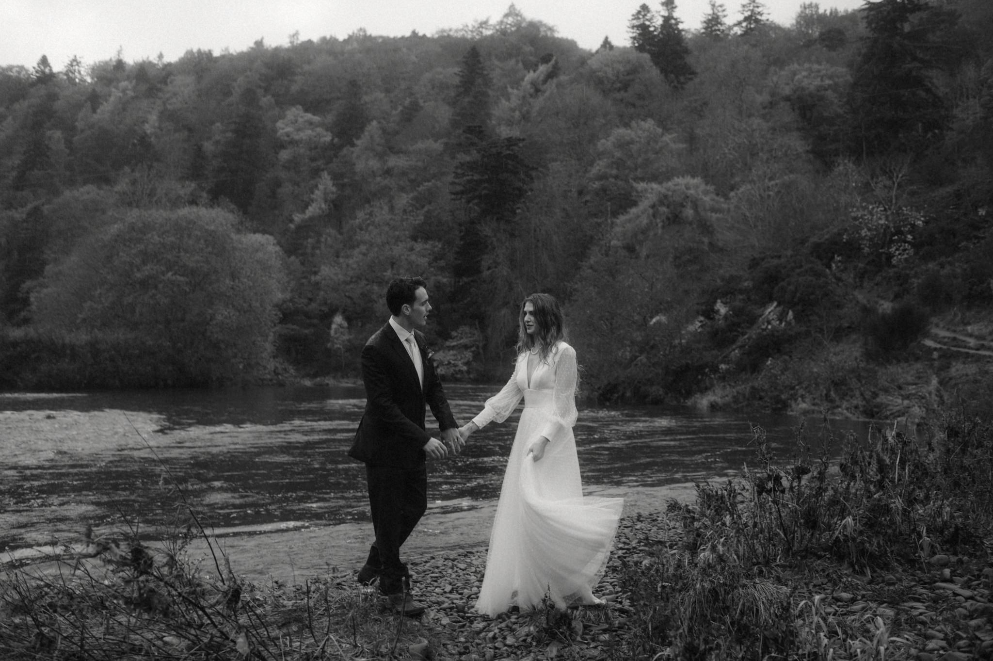 scottish elopement at neidpath castle with bride and groom walking down near the castle grounds