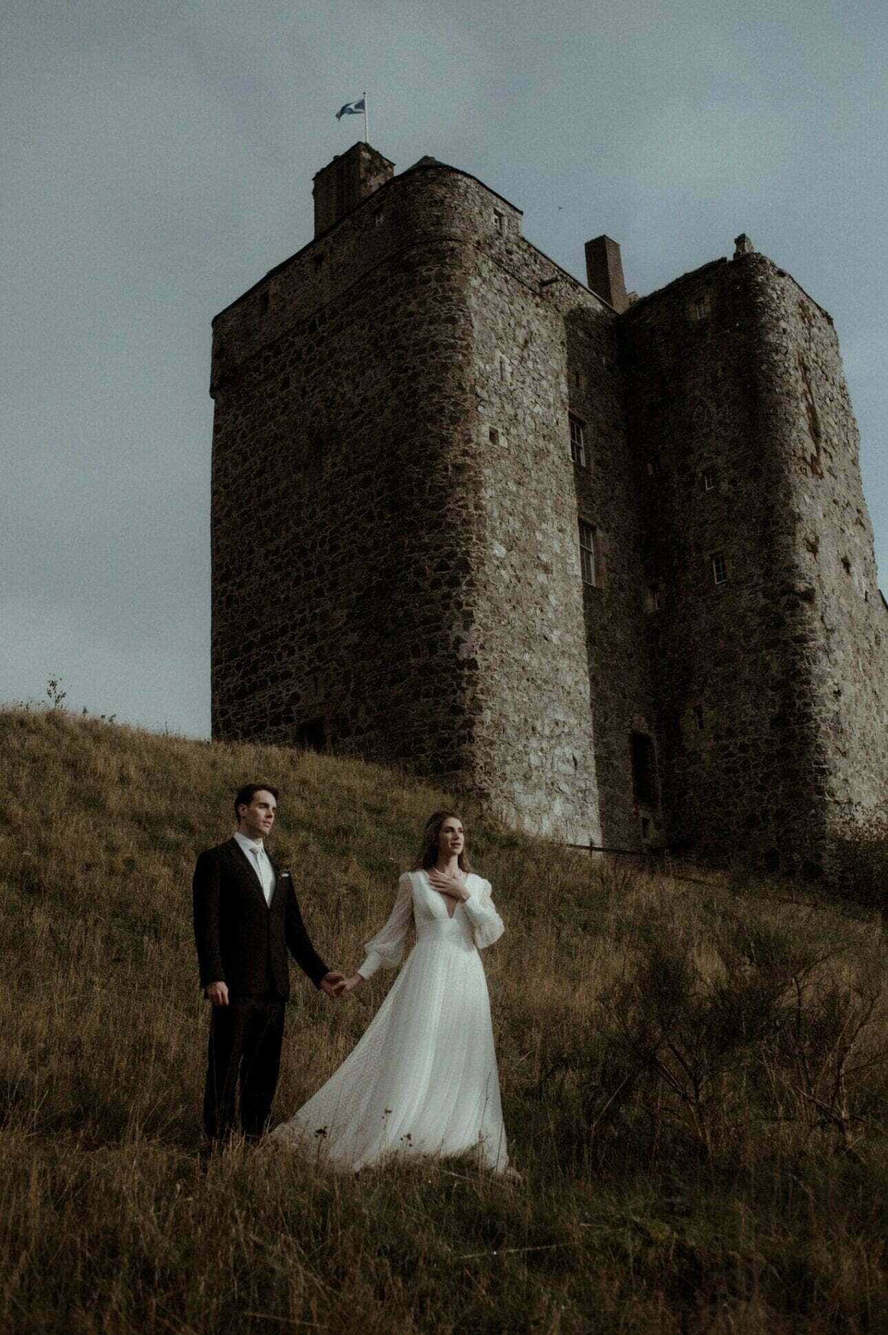 scottish castle wedding at neidpath couple standing in front of the castle