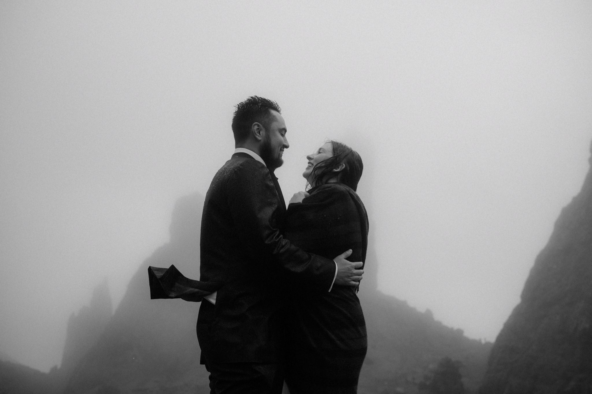 An elopement in Scotland outdoors in the rain with Bride and groom kissing near the Old man of Storr on Skye