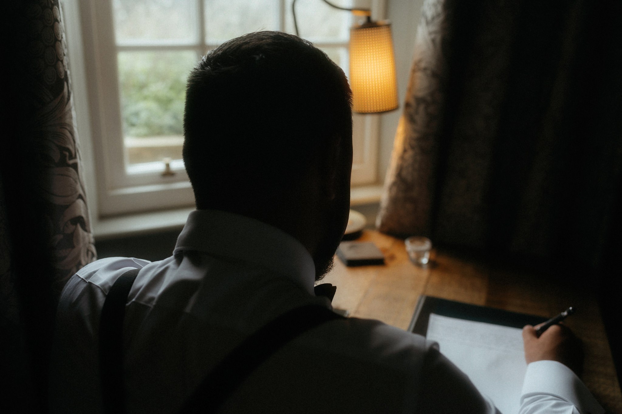 elopement in scotland. Groom writing vows by a window. photo by sean bell