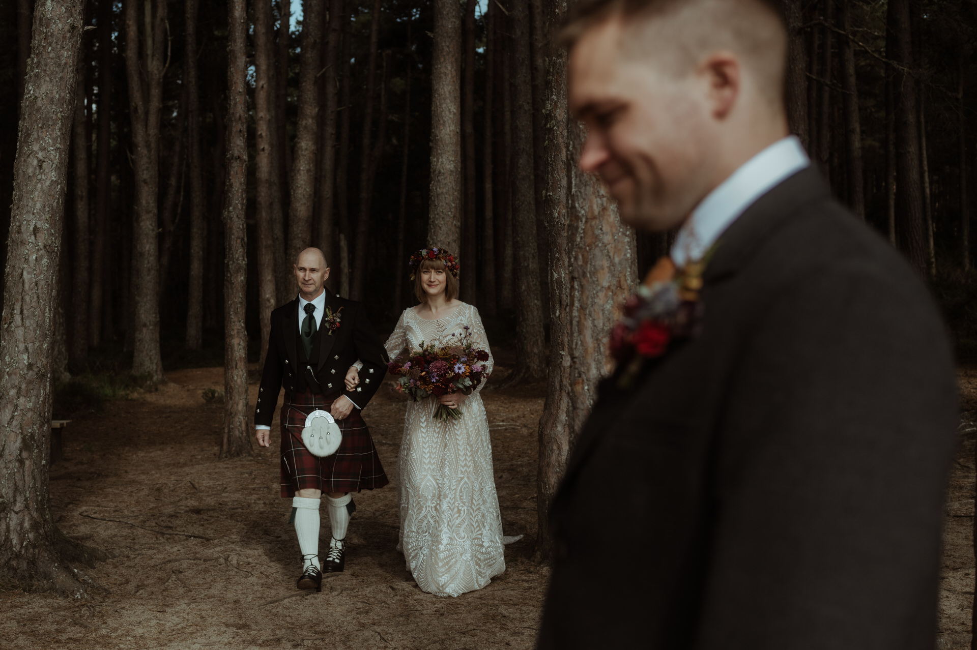 Dad walks bride through woodland during elopement on Loch Garten in the Scottish Highlands