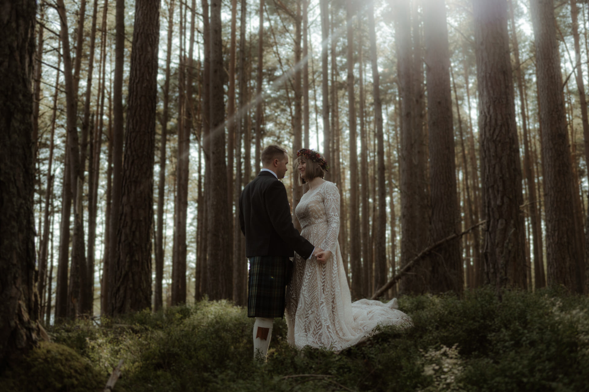 Bride and Groom laughing whilst exploring the woodland on a Sunny day during their Scottish elopement