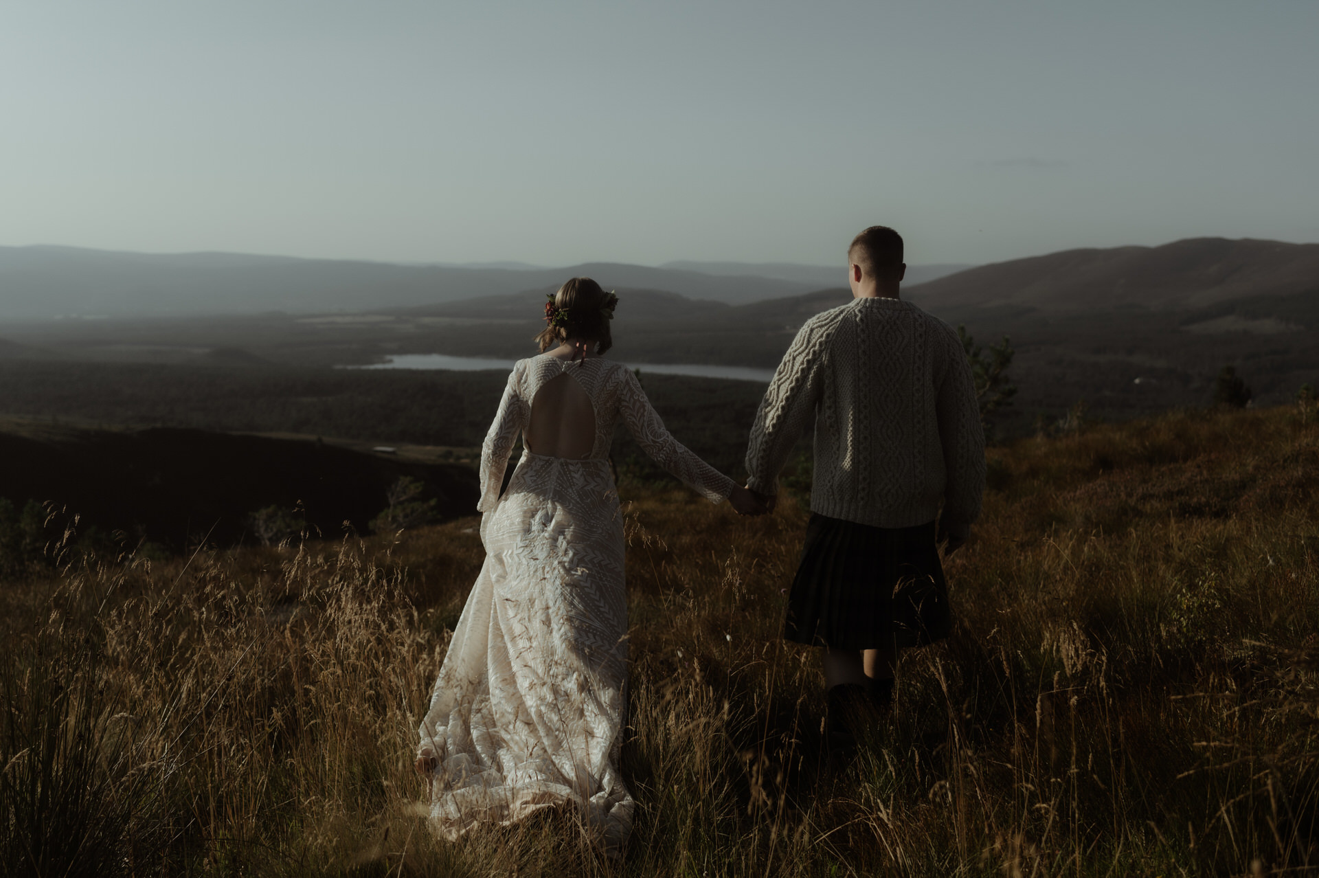 late afternoon light in the cairngorm mountains with bride and groom walking