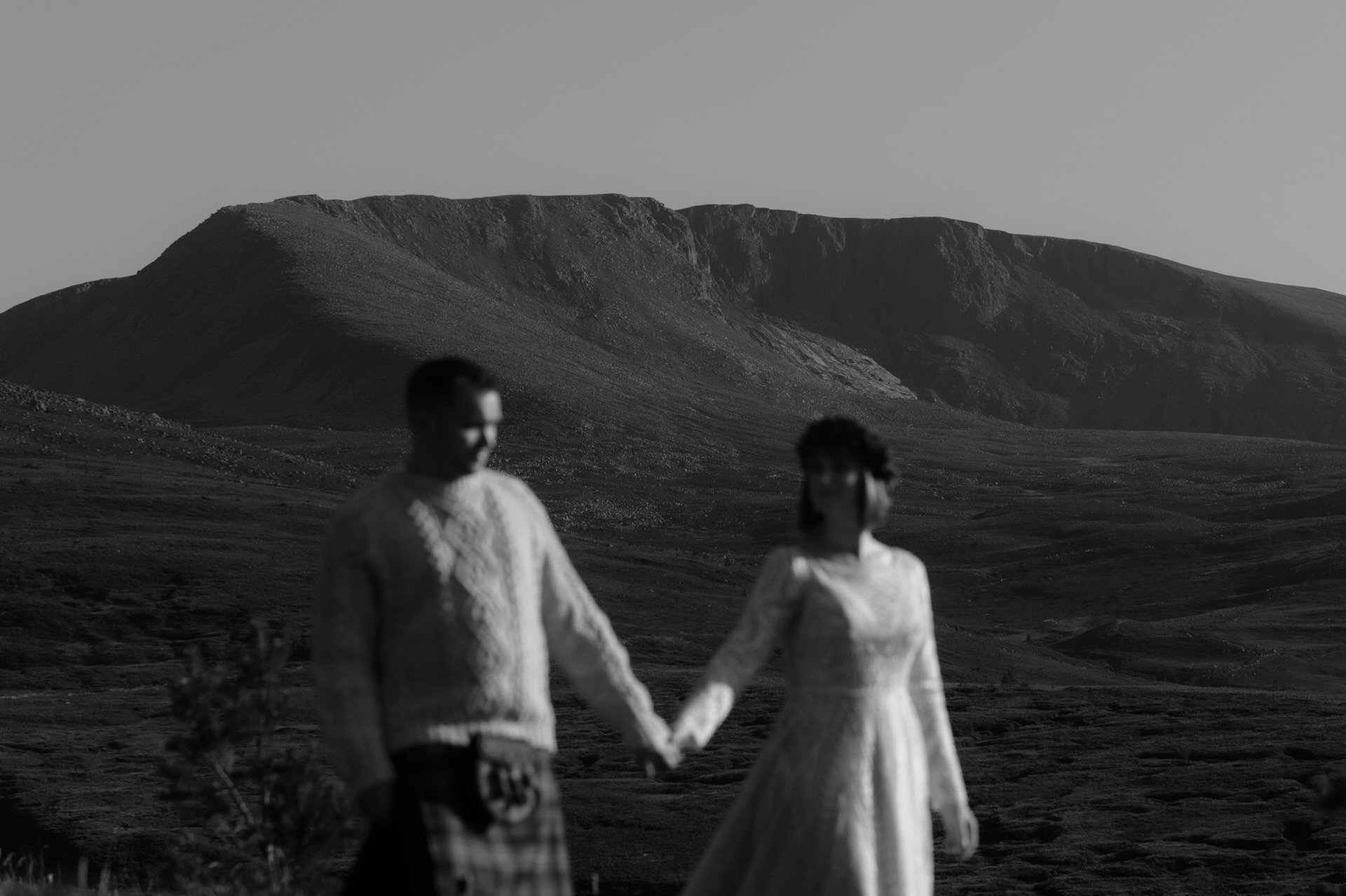 Sunshine on the Cairngorm mountains in Scotland with Bride and Groom walking, running, hugging and laughing in the foreground