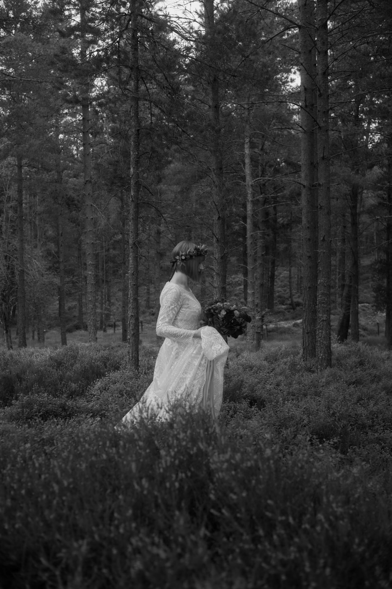 Bride in White dress walking through woodland in Scotland Highlands