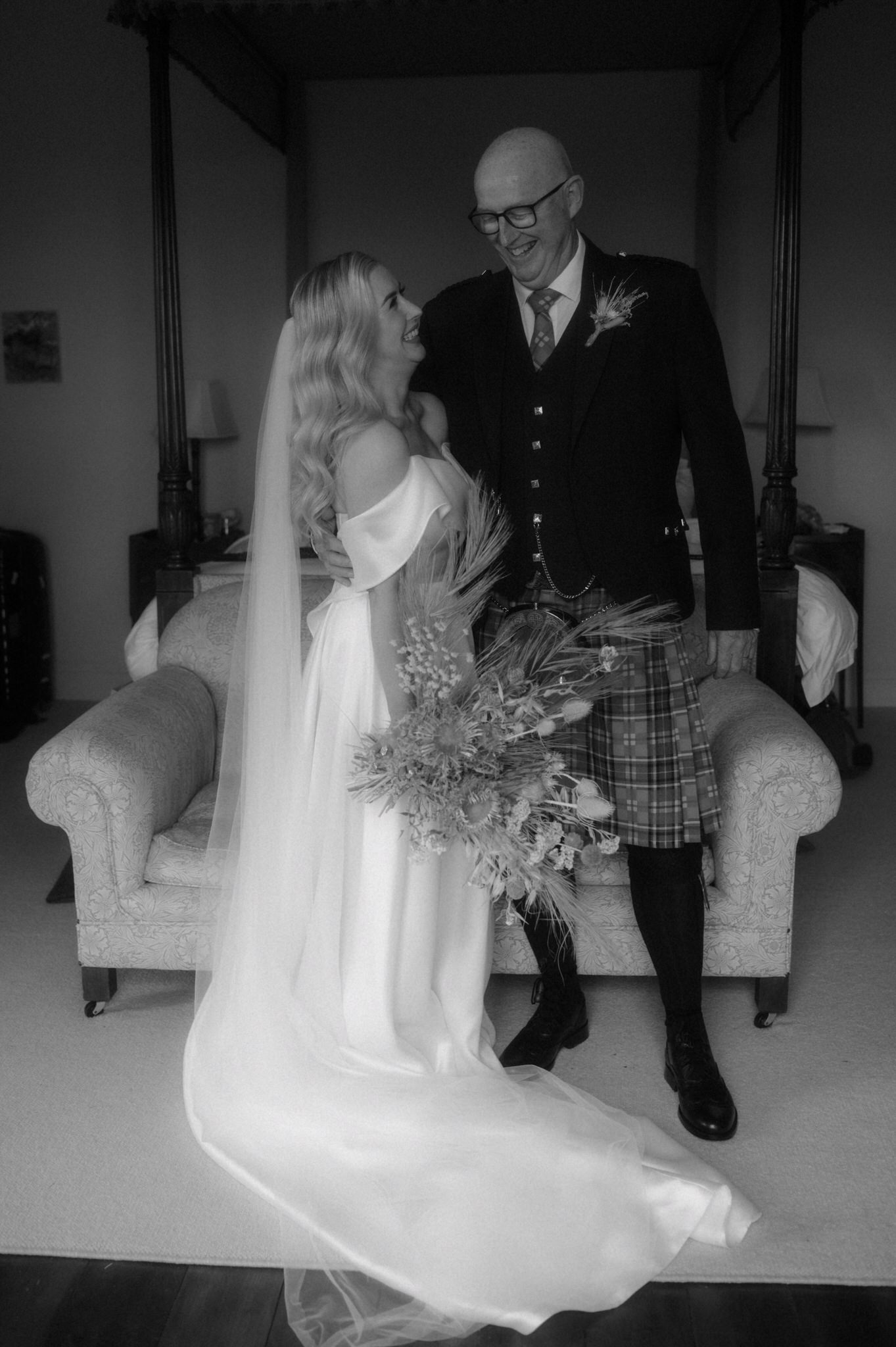 bride and her dad laughing during wedding preparations in a room in a castle in scotland