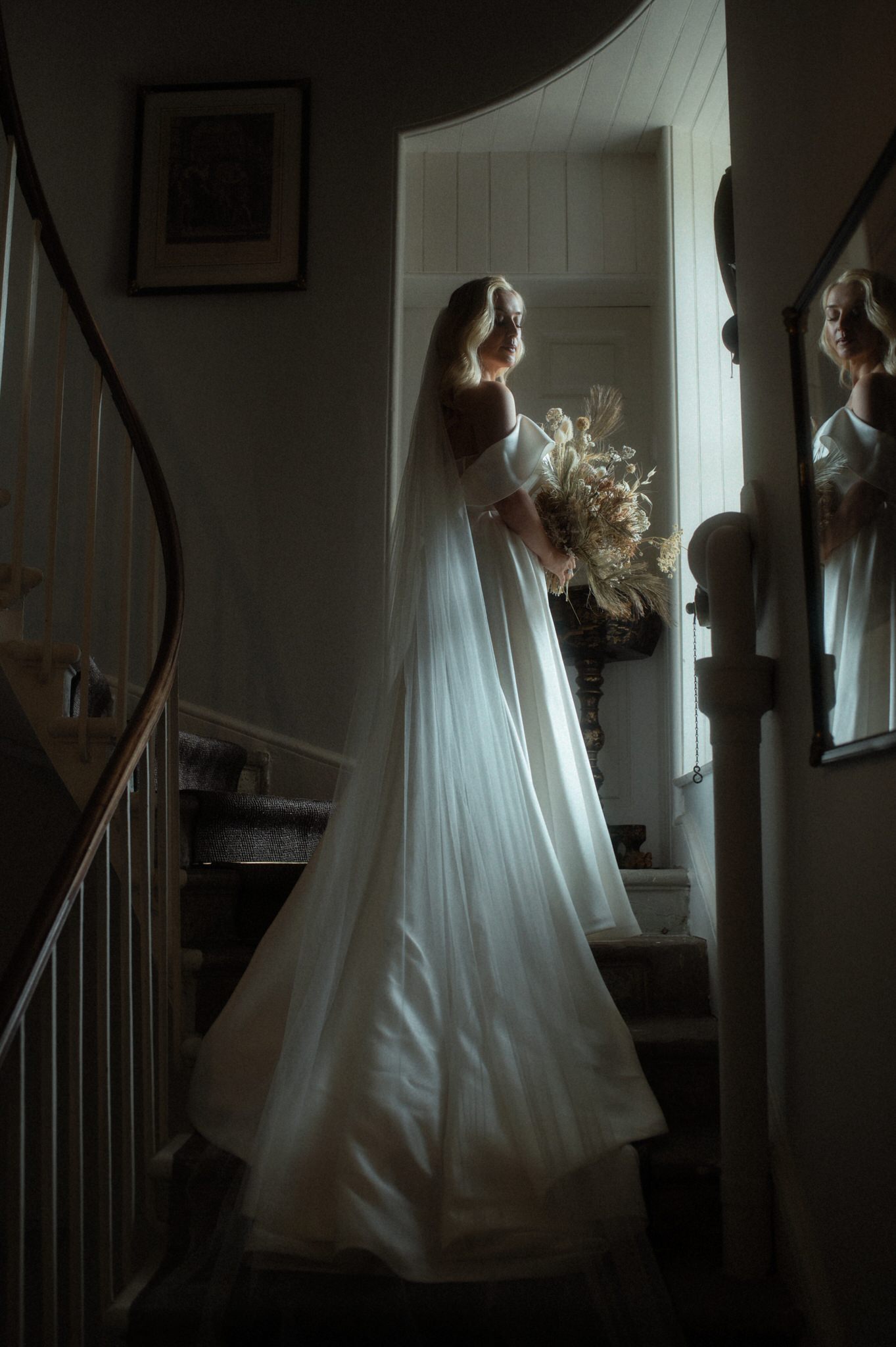 striking bridal portrait in the window light of a Scottish Castle with dress and veil flowing