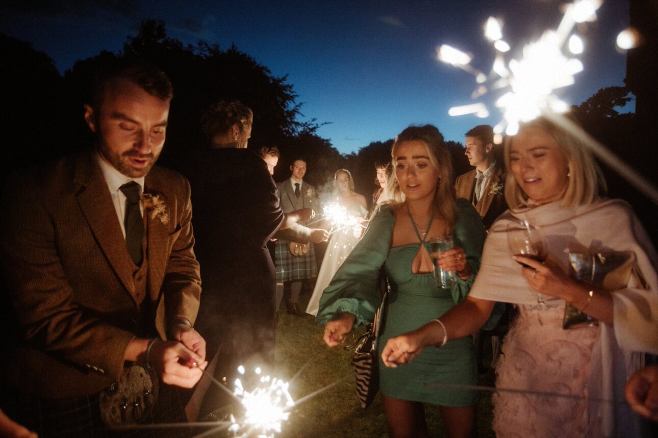 bride and groom dancing and running in sparklers during their wedding day in Scotland