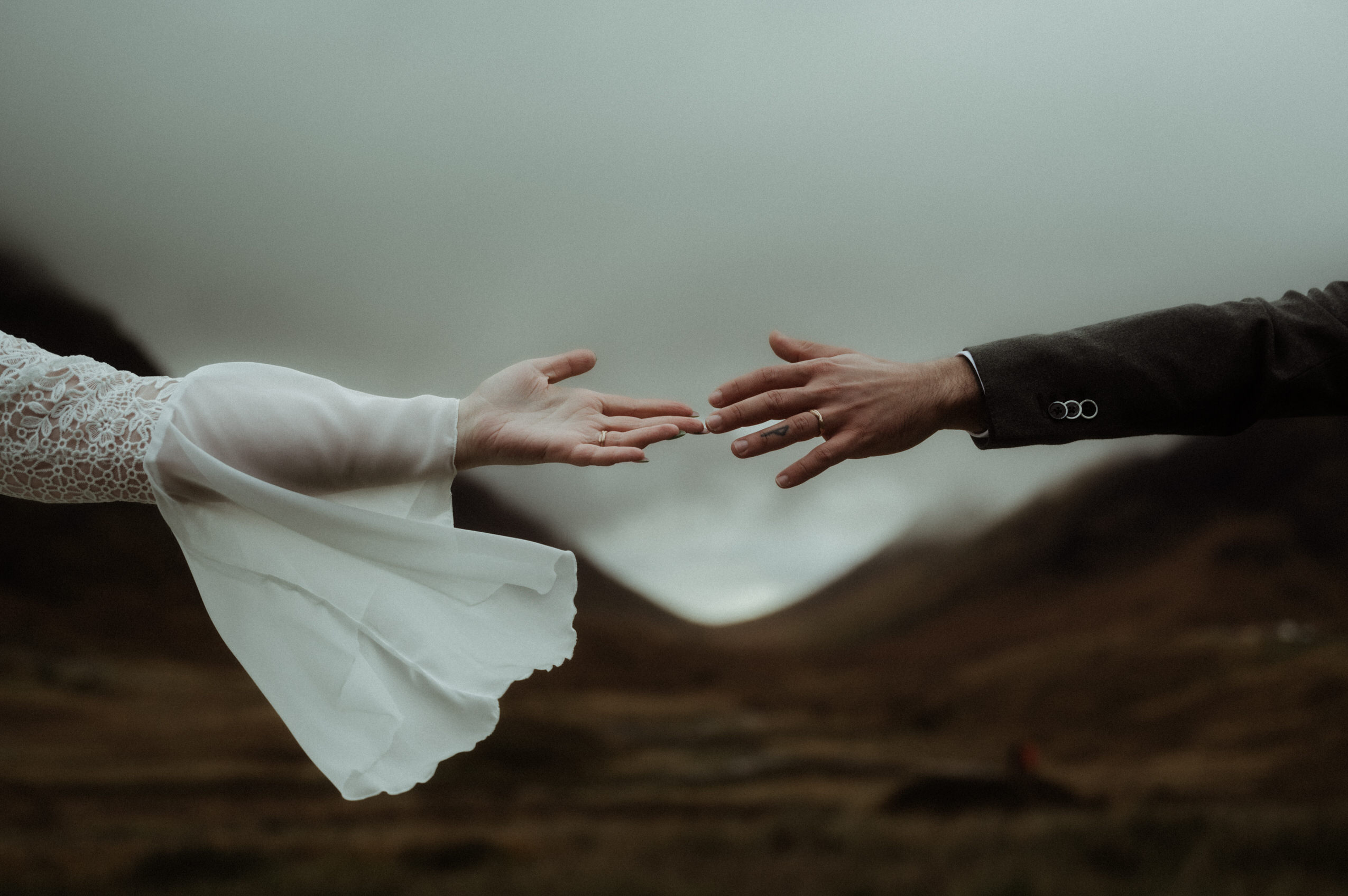 a couple who eloped to scotland holding hands in the mountains of Glencoe