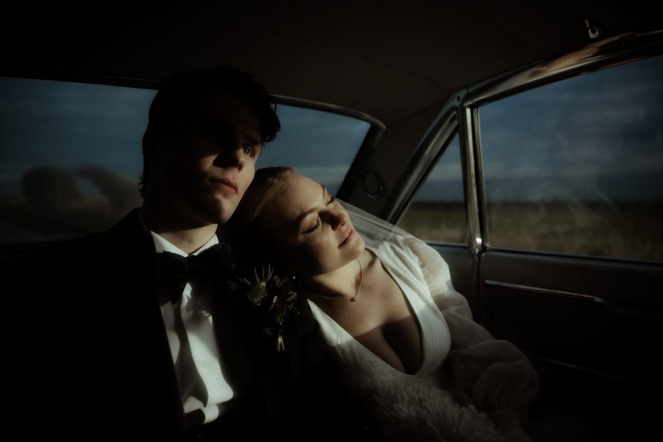 young couple in a vintage wedding car with sunlight streaming through window during their Scottish elopement