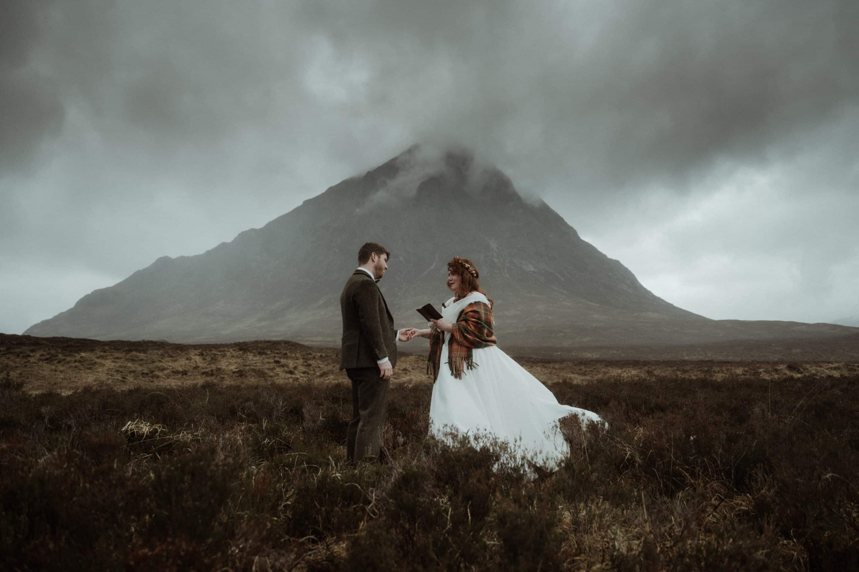 elope to scotland couple saying ow in glencoe with the mountains behind them