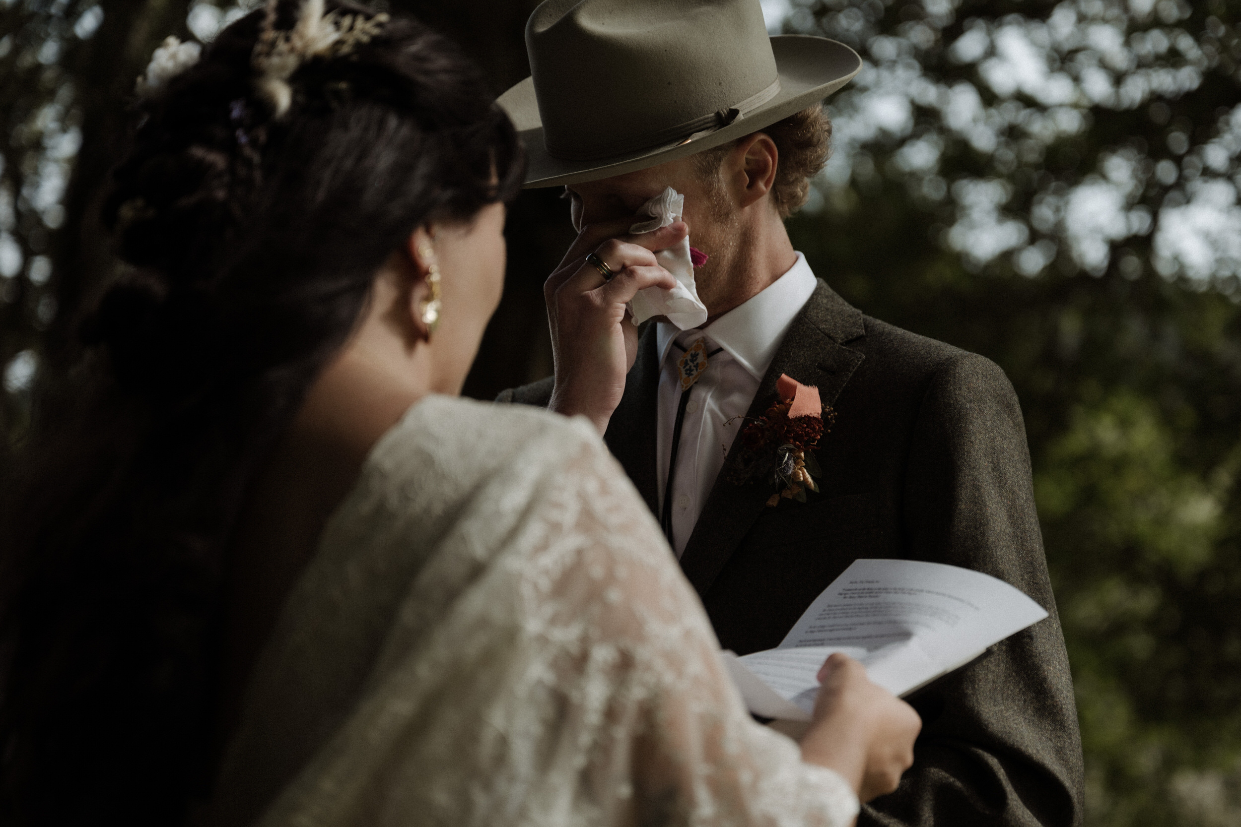 an elopement ceremony between the trees near Castle Lachlan in the Scottish Highlands with a groom wearing a stetson crying during the vows