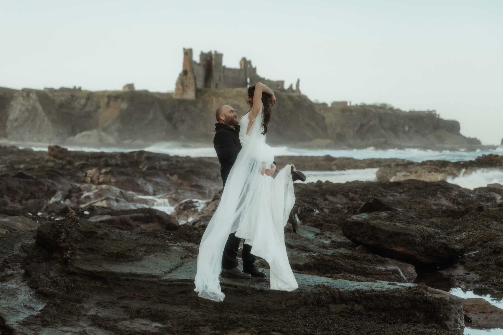 how much does it cost to elope in scotland couple hugging near a beach near Edinburgh