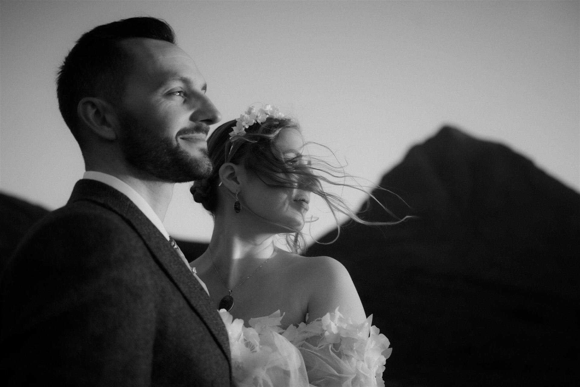 a couple who eloped to assynt looking out across the mountain of silvan