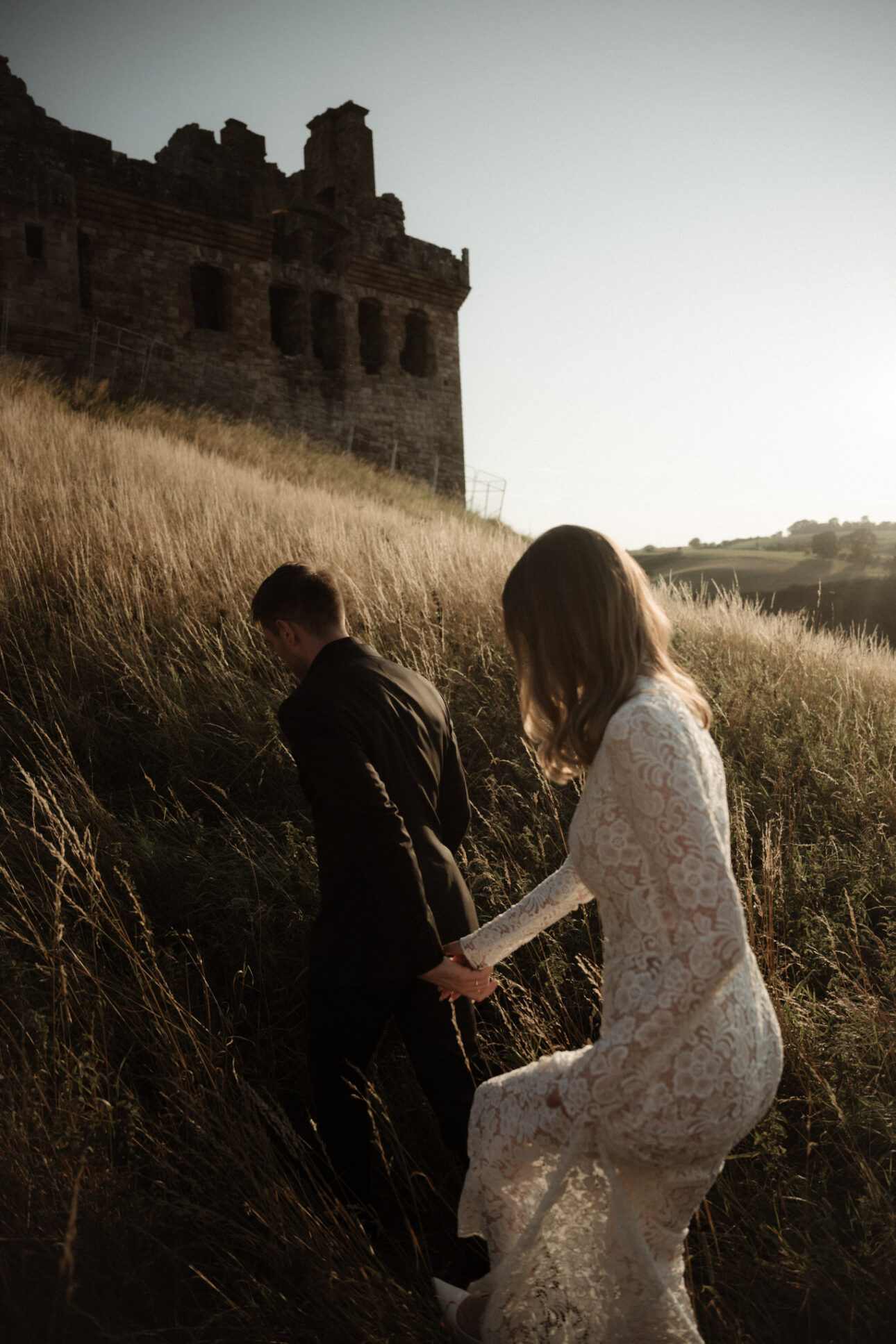 elope to scotland couple walking near to Crichton castle 