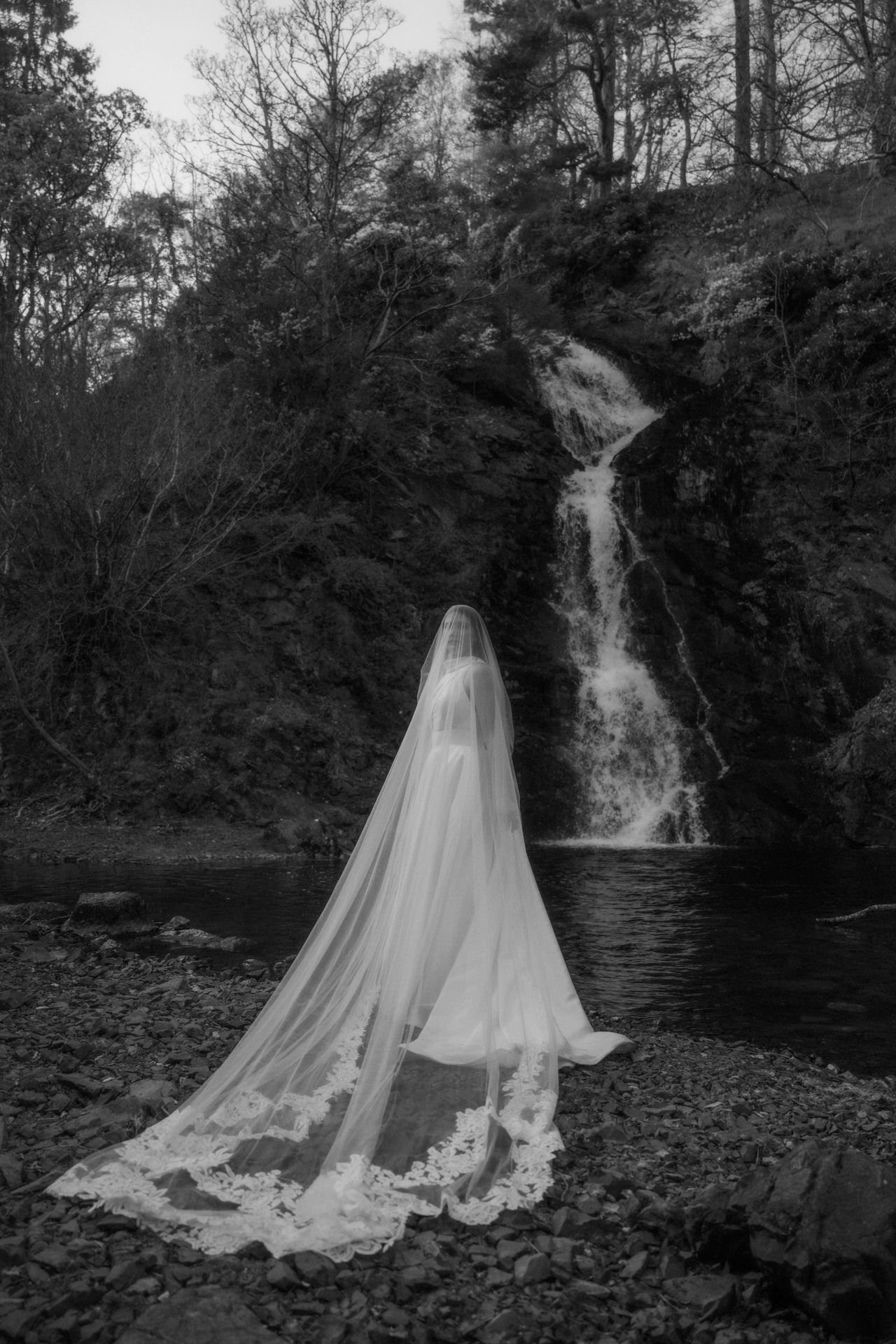 scotland elopement bride standing next to a waterfall 